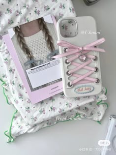 a cell phone case with pink laces on it and a card attached to the back