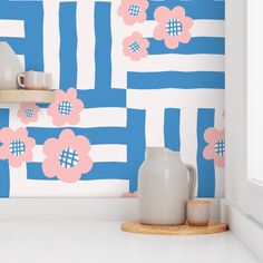 a white vase sitting on top of a counter next to a blue and white wall