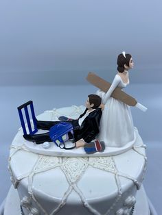 a wedding cake topper with a bride and groom laying on the ground next to each other