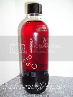 a bottle of red liquid sitting on top of a table