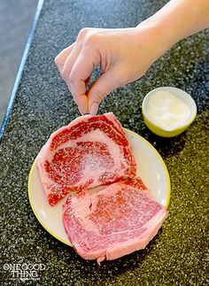 a person is cutting up some meat on a plate