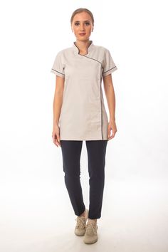 Step up your spa or hotel uniform game with this short-sleeve, mock-neck women's tunic featuring handy side snaps. Perfect for a variety of professional settings, including spa attendant and hotel staff uniforms. You could personalize your spa tunic with embroidery. The black bias tape detail adds a touch of sophistication and elegance to the design, making it suitable for various professional settings. It is perfect for spa attendants, hotel staff, and other professionals who want to look and feel their best while on the job. Spa Employee Outfit, Hotel Uniform Design, Spa Uniform, Beauty Tunics, Hotel Uniform, Staff Uniforms, Hotel Staff, Uniform Design, Short Sleeve Tunic