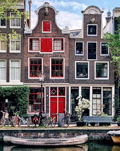 a row of houses with bicycles parked on the street next to each other in front of a body of water