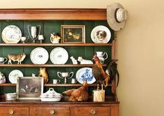 an old china cabinet with plates and chickens on it