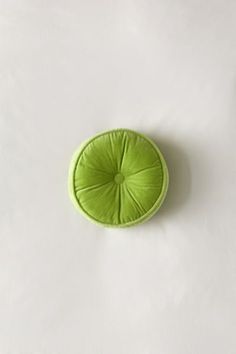 a green round cushion sitting on top of a white table