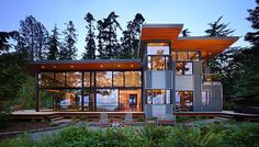 a modern house in the woods with lots of windows