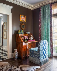 a living room filled with furniture next to a window covered in green and blue curtains