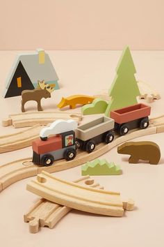 a wooden toy train set with animals and trees