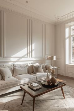 a living room filled with white furniture and lots of light coming in from the windows