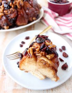 a piece of bread with raisins and nuts on it sitting on a plate