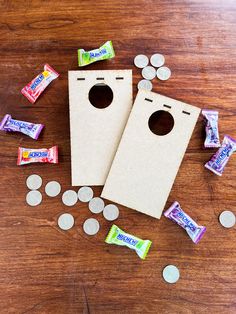 two paper bags with candy and coins scattered around them on top of a wooden table