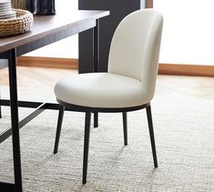 a white chair sitting in front of a wooden table