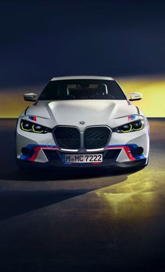 the front end of a white car with red, blue and yellow stripes on it