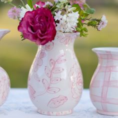 three vases with flowers in them sitting on a table