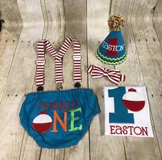 some items are laying out on a wooden floor and one is wearing a birthday hat