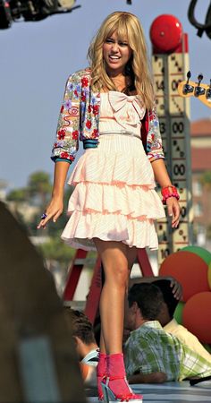 a woman is walking down the street in pink shoes