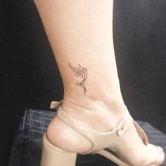 a woman's foot with a small bird tattoo on her left ankle and heel