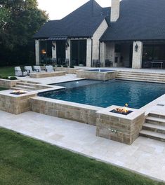 a pool with steps leading up to it and a fire pit in the middle next to it