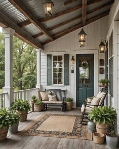 a porch with two chairs and potted plants on the front porch, along with an area rug