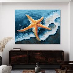 a starfish painting hanging on the wall above a dresser