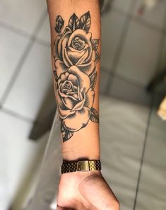 a woman's arm with a black and white rose tattoo on the left wrist