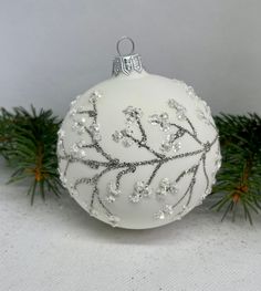 a white ornament decorated with silver beads