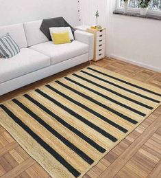 a living room with a white couch and black and yellow striped rug on the floor