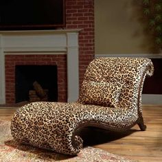 a leopard print chaise lounge chair in front of a fireplace