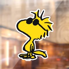 a sticker depicting a yellow bird with black eyes on it's head and legs