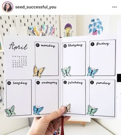 a person holding up a calendar with butterflies on it