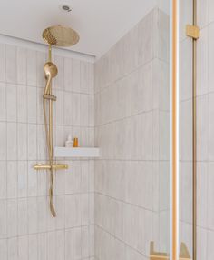 a bathroom with a shower head and white tile walls