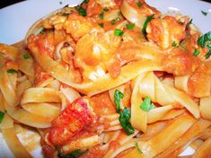 pasta with tomato sauce and spinach leaves on top, sitting on a white plate