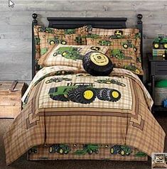 a bed room with a tractor themed comforter and two night stands on the floor