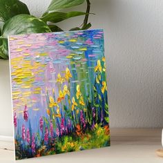 a painting of flowers on a table next to a potted plant art board print