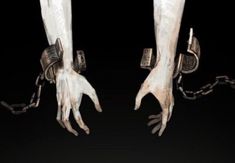 two hands chained to each other with chains around them and handcuffs hanging from the wrists