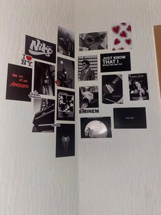 a refrigerator covered in stickers and magnets next to a wall with pictures on it