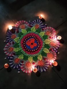 an intricately decorated diya with candles on the ground