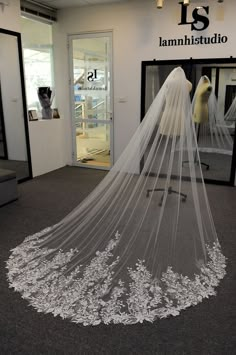 a wedding veil on display in front of a mannequin