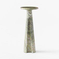 a tall green vase sitting on top of a white table