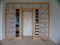 an empty room with open doors and closets