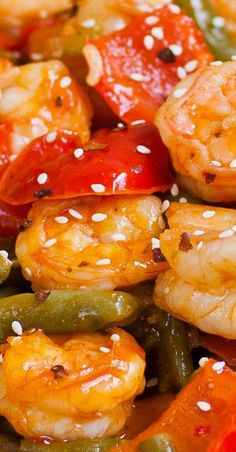 shrimp, peppers, and green beans in a stir - fry dish with sesame seeds