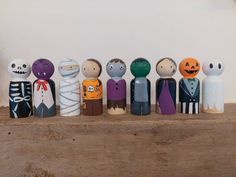 a group of wooden toy figurines sitting on top of a wooden table next to each other