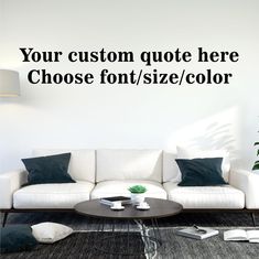 a living room with a white couch and coffee table in front of a wall that says, your custom quote here choose font / size / color