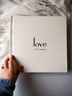 someone is holding up a book that says love in the moment