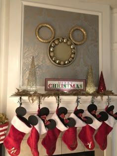 christmas stockings hanging from the mantel with mickey mouse ears on them and other holiday decorations