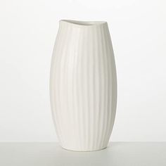 a white vase sitting on top of a table