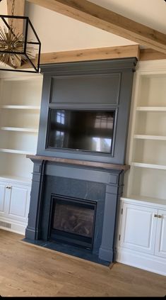 an empty living room with built in bookcases and a fireplace