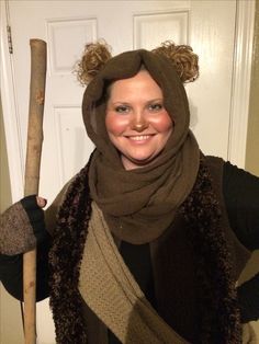 a woman wearing a bear hat and scarf holding a baseball bat