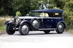 an antique car is parked on the side of the road