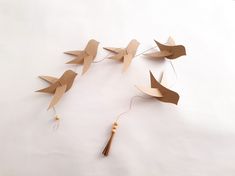 a group of paper birds on a white surface with string attached to the back of them